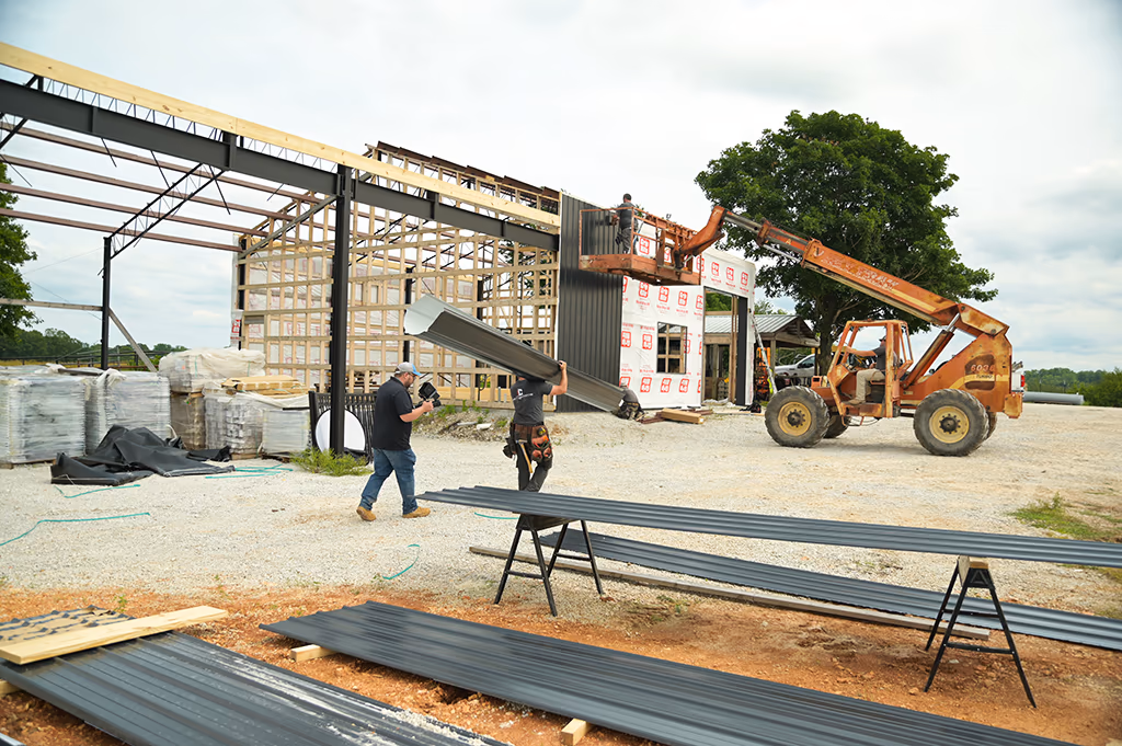 An Integrity Contracting crew member on site beside a partly clad metal building